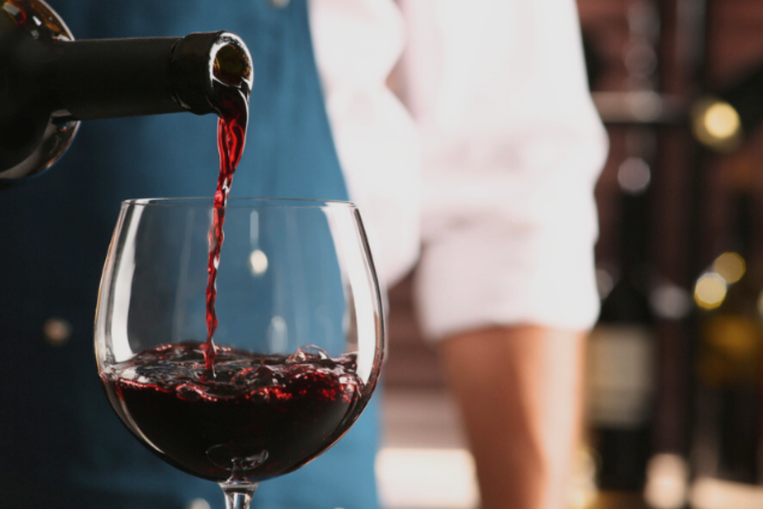 Red wine being poured into a glass for a corporate event