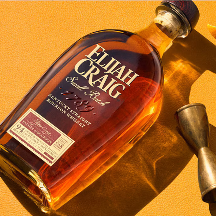 Bottle of Elijah Craig bourbon whiskey on a yellow background